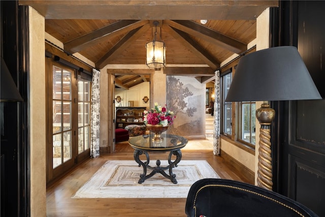 sitting room featuring vaulted ceiling with beams, a healthy amount of sunlight, wood ceiling, and wood finished floors