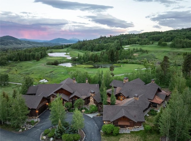 aerial view at dusk featuring a water and mountain view