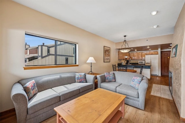 living room featuring baseboards and light wood-type flooring
