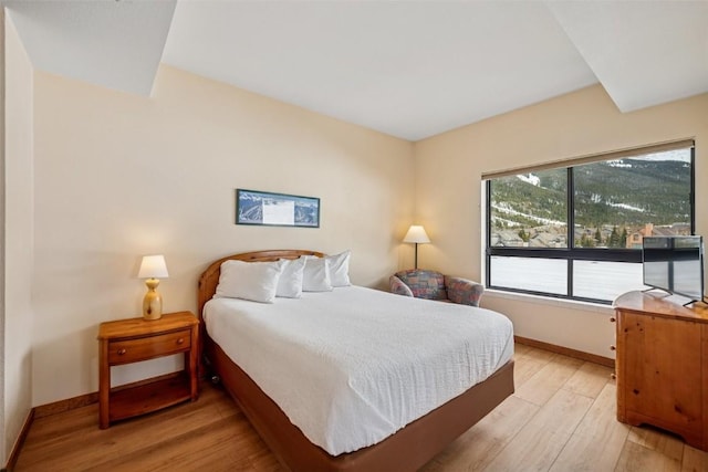 bedroom featuring baseboards and light wood finished floors