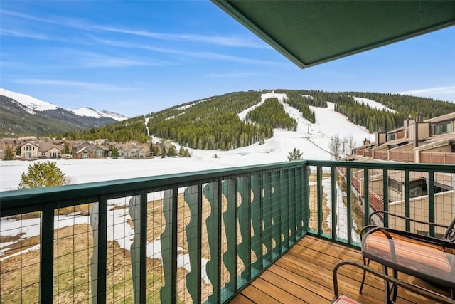 snow covered back of property with a mountain view