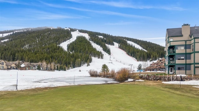 surrounding community with a yard, a wooded view, and a mountain view