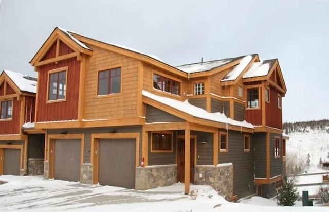 view of front of home featuring an attached garage and stone siding