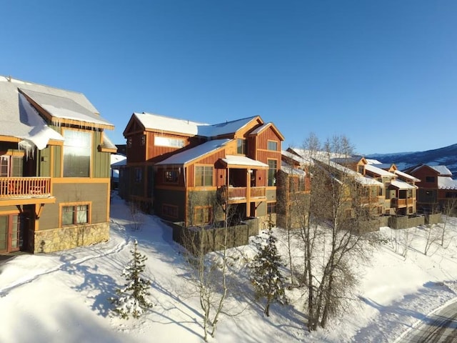 view of snowy exterior featuring stone siding