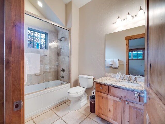 full bathroom featuring toilet, a healthy amount of sunlight, vanity, and tile patterned floors