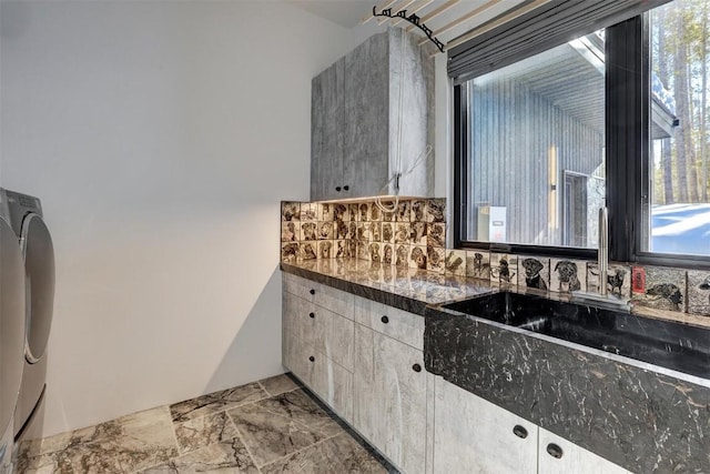 kitchen with plenty of natural light, a sink, backsplash, and dark countertops