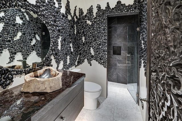 bathroom with toilet, vanity, and a walk in shower