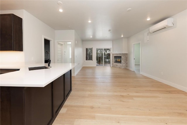 35 Argentine Ct Unit 307, Keystone, CO 80435 - kitchen featuring a wall mounted AC, light countertops, dark brown cabinetry, light wood-style floors, and open floor plan