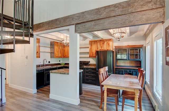 3020 Village Dr Unit 222, Steamboat Springs, CO 80487 - kitchen featuring a chandelier, black dishwasher, freestanding refrigerator, light wood-style flooring, and dark countertops