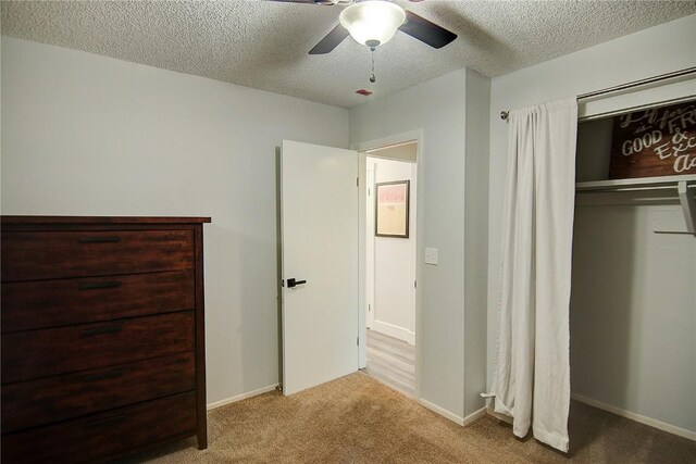 3020 Village Dr Unit 222, Steamboat Springs, CO 80487 - unfurnished bedroom featuring carpet floors, a textured ceiling, a closet, and a ceiling fan