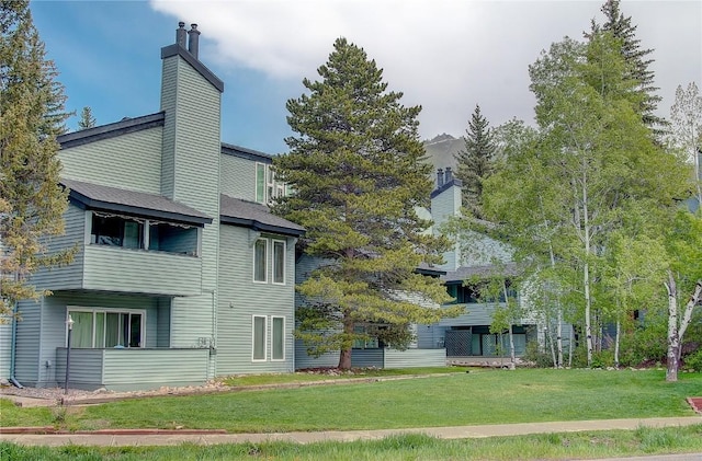 3020 Village Dr Unit 222, Steamboat Springs, CO 80487 - rear view of property with a chimney and a yard
