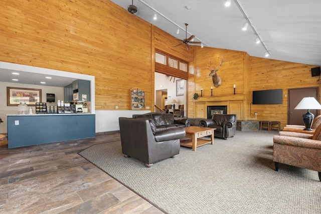 2700 Village Dr Unit 301, Steamboat Springs, CO 80487 - living area featuring wood walls, ceiling fan, track lighting, high vaulted ceiling, and a glass covered fireplace
