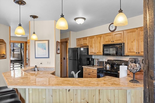 2700 Village Dr Unit 301, Steamboat Springs, CO 80487 - kitchen featuring black appliances, a peninsula, tile countertops, and pendant lighting