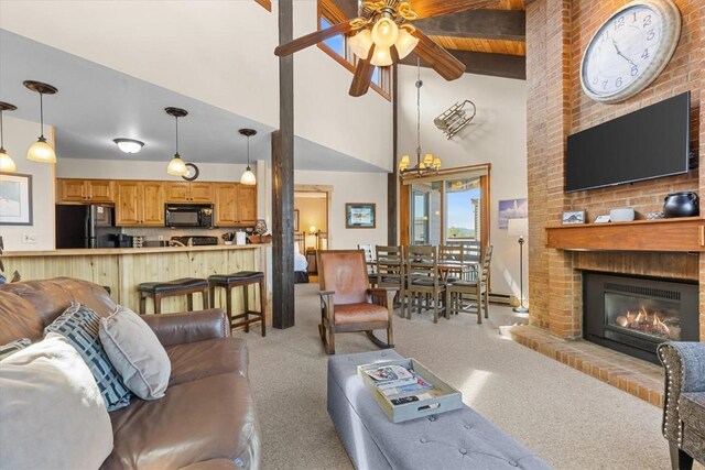 2700 Village Dr Unit 301, Steamboat Springs, CO 80487 - living area featuring a ceiling fan, carpet, a brick fireplace, high vaulted ceiling, and beam ceiling