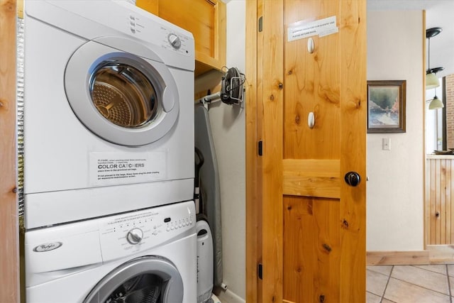 2700 Village Dr Unit 301, Steamboat Springs, CO 80487 - laundry area featuring stacked washing machine and dryer, light tile patterned flooring, and baseboards