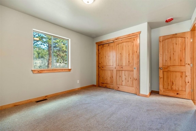 unfurnished bedroom with visible vents, baseboards, and carpet flooring