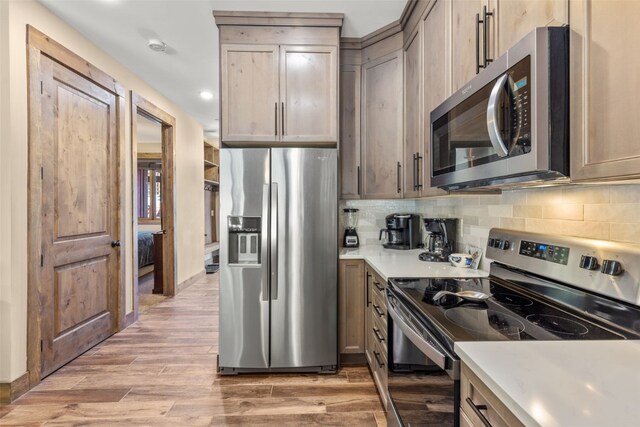 102 Lake Ridge Cir Unit 1887, Keystone, CO 80435 - kitchen with appliances with stainless steel finishes, light countertops, backsplash, light wood-style flooring, and recessed lighting