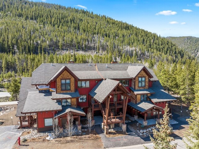 102 Lake Ridge Cir Unit 1887, Keystone, CO 80435 - view of front of home with a forest view, a shingled roof, a chimney, and a mountain view