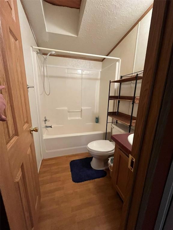 315 E 1st St, Oak Creek, CO 80467 - full bath featuring washtub / shower combination, wood finished floors, toilet, vanity, and a textured ceiling