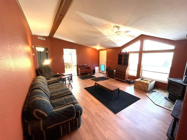 315 E 1st St, Oak Creek, CO 80467 - living room featuring lofted ceiling, wood finished floors, a wood stove, visible vents, and ceiling fan
