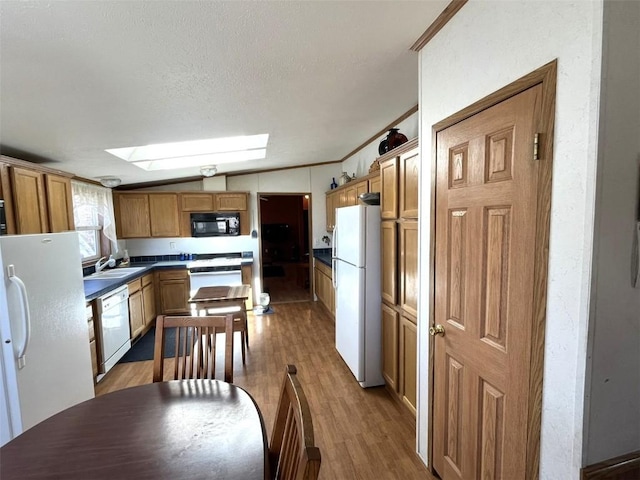 315 E 1st St, Oak Creek, CO 80467 - kitchen featuring white appliances, a sink, dark wood-type flooring, and vaulted ceiling with skylight