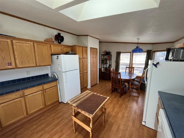 315 E 1st St, Oak Creek, CO 80467 - kitchen with crown molding, light wood-style floors, a skylight, and freestanding refrigerator
