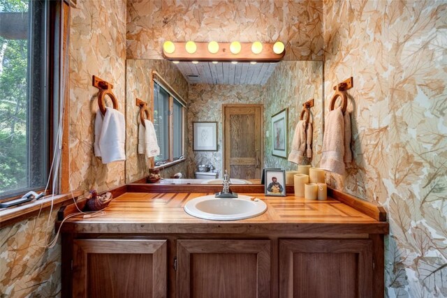 2350 Glacier Rdg, Steamboat Springs, CO 80487 - bathroom featuring toilet, a healthy amount of sunlight, vanity, and wallpapered walls
