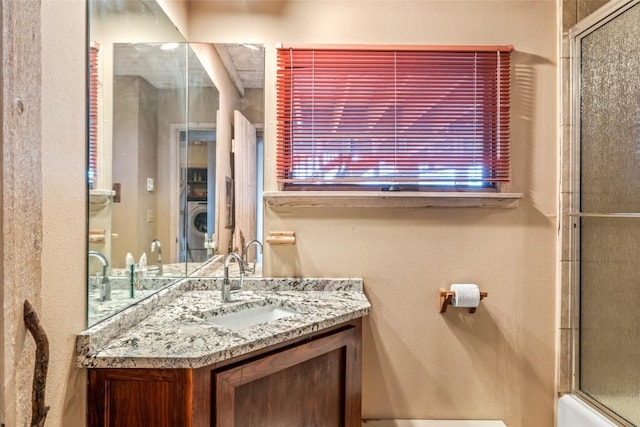 2350 Glacier Rdg, Steamboat Springs, CO 80487 - full bath featuring a shower with shower door, vanity, and washer / clothes dryer