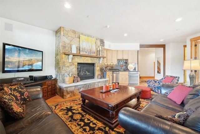 living room featuring a fireplace, recessed lighting, visible vents, and light wood-type flooring