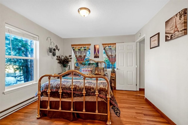 850 Georgia Pass, Lookout, Jefferson, CO 80456 - bedroom with a baseboard heating unit, baseboards, and wood finished floors