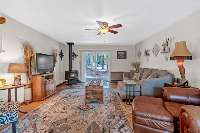 850 Georgia Pass, Lookout, Jefferson, CO 80456 - living area with a wood stove, baseboards, light wood-style floors, and ceiling fan