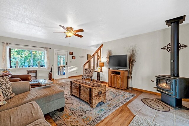 850 Georgia Pass, Lookout, Jefferson, CO 80456 - living room with baseboards, a ceiling fan, a wood stove, and stairs