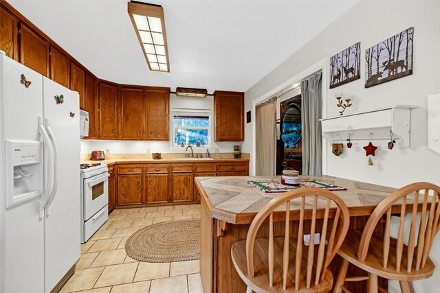 850 Georgia Pass, Lookout, Jefferson, CO 80456 - kitchen featuring brown cabinets, a sink, white appliances, and light tile patterned floors