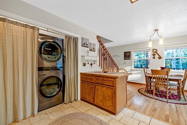 850 Georgia Pass, Lookout, Jefferson, CO 80456 - washroom featuring stacked washer and dryer, light tile patterned floors, and laundry area