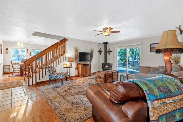 850 Georgia Pass, Lookout, Jefferson, CO 80456 - living area featuring stairway, a wood stove, a ceiling fan, light wood-type flooring, and a textured ceiling