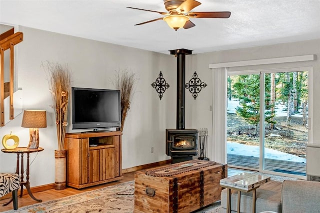 850 Georgia Pass, Lookout, Jefferson, CO 80456 - living area featuring wood finished floors, a wood stove, baseboards, and ceiling fan