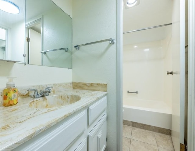 bathroom with tile patterned flooring, vanity, and  shower combination