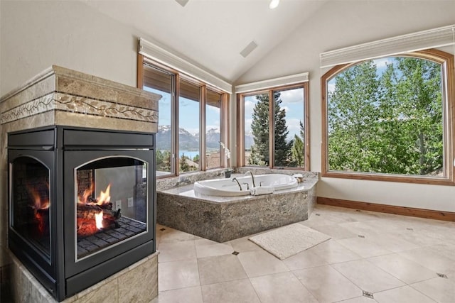 17 James Ct, Dillon, CO 80435 - full bathroom featuring plenty of natural light, a premium fireplace, a garden tub, vaulted ceiling, and a water view