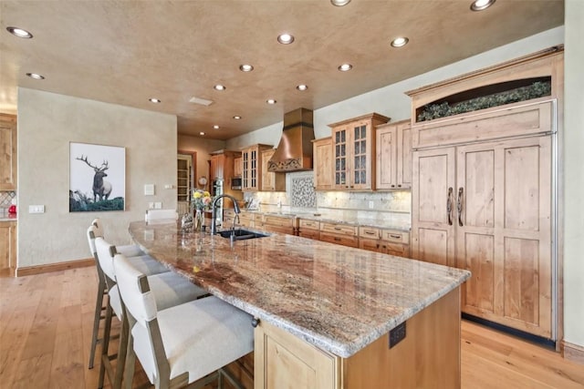 17 James Ct, Dillon, CO 80435 - kitchen featuring wall chimney exhaust hood, a spacious island, light wood-type flooring, recessed lighting, and light stone countertops