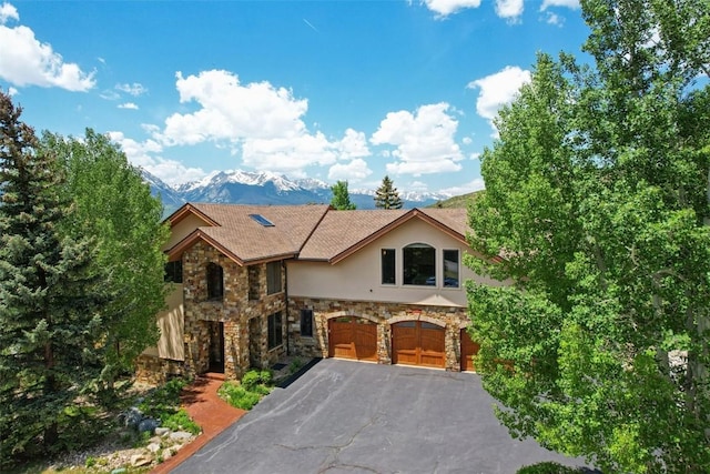 17 James Ct, Dillon, CO 80435 - view of front facade featuring a garage, stone siding, stucco siding, asphalt driveway, and a mountain view
