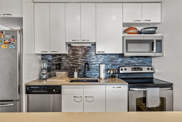 21 Cypress Ct, Steamboat Springs, CO 80487 - kitchen featuring stainless steel appliances, a sink, white cabinetry, light countertops, and decorative backsplash