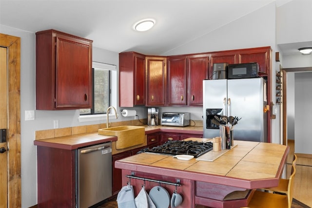 2349 Michigan Hill Rd, Jefferson, CO 80456 - kitchen featuring stainless steel appliances, a sink, tile counters, lofted ceiling, and dark brown cabinets