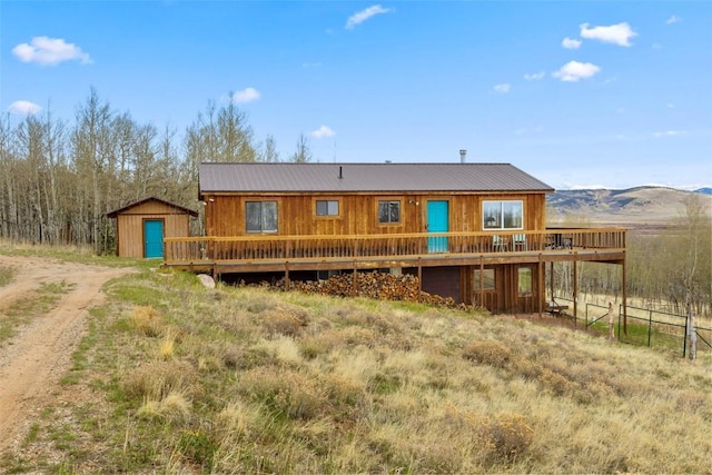 2349 Michigan Hill Rd, Jefferson, CO 80456 - rear view of house with a wooden deck, metal roof, and dirt driveway