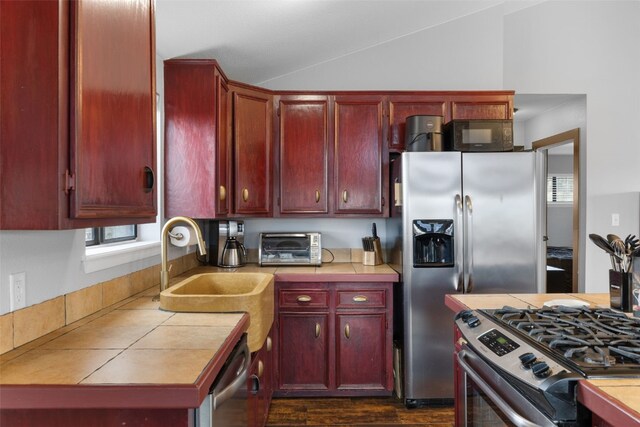 2349 Michigan Hill Rd, Jefferson, CO 80456 - kitchen with appliances with stainless steel finishes, dark brown cabinets, tile countertops, a sink, and vaulted ceiling