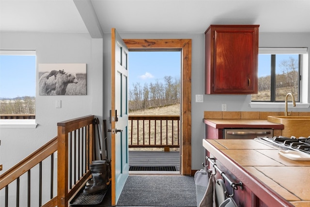 2349 Michigan Hill Rd, Jefferson, CO 80456 - kitchen with tile countertops, a sink, dishwashing machine, reddish brown cabinets, and stovetop