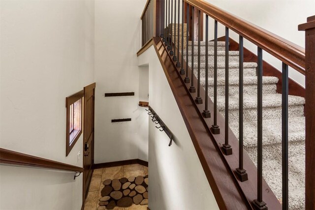 830 Blue River Pkwy Unit 203, Silverthorne, CO 80498 - stairway featuring baseboards and a high ceiling
