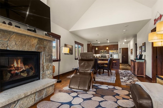 830 Blue River Pkwy Unit 203, Silverthorne, CO 80498 - living room with dark wood-style flooring, a fireplace, baseboards, and high vaulted ceiling