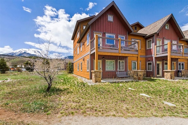 830 Blue River Pkwy Unit 203, Silverthorne, CO 80498 - view of front of property with board and batten siding, a balcony, a mountain view, a patio, and a front lawn