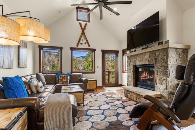 830 Blue River Pkwy Unit 203, Silverthorne, CO 80498 - living area with a ceiling fan, high vaulted ceiling, a fireplace, wood finished floors, and baseboards