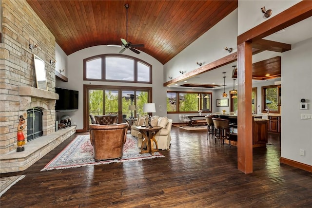1115 Steamboat Blvd, Steamboat Springs, CO 80487 - living area featuring a ceiling fan, wooden ceiling, a stone fireplace, dark wood-style floors, and baseboards